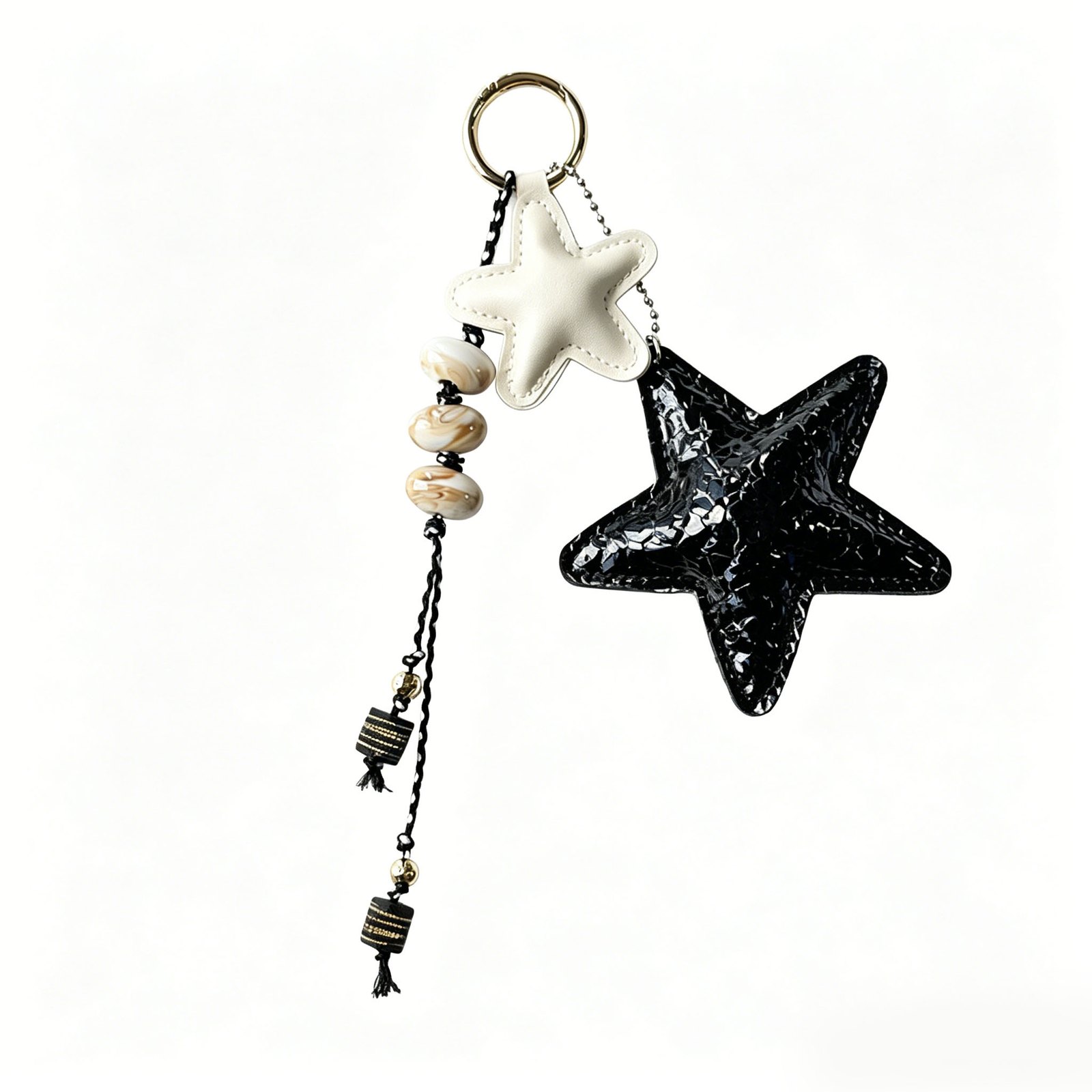 Two star charms with bead accents and round ring in black, cream, tan, silver-tone, shown as a keychain.