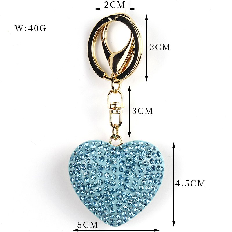 Heart-shaped rhinestone pendant with ring and clip in blue, gold-tone, shown as a keychain.