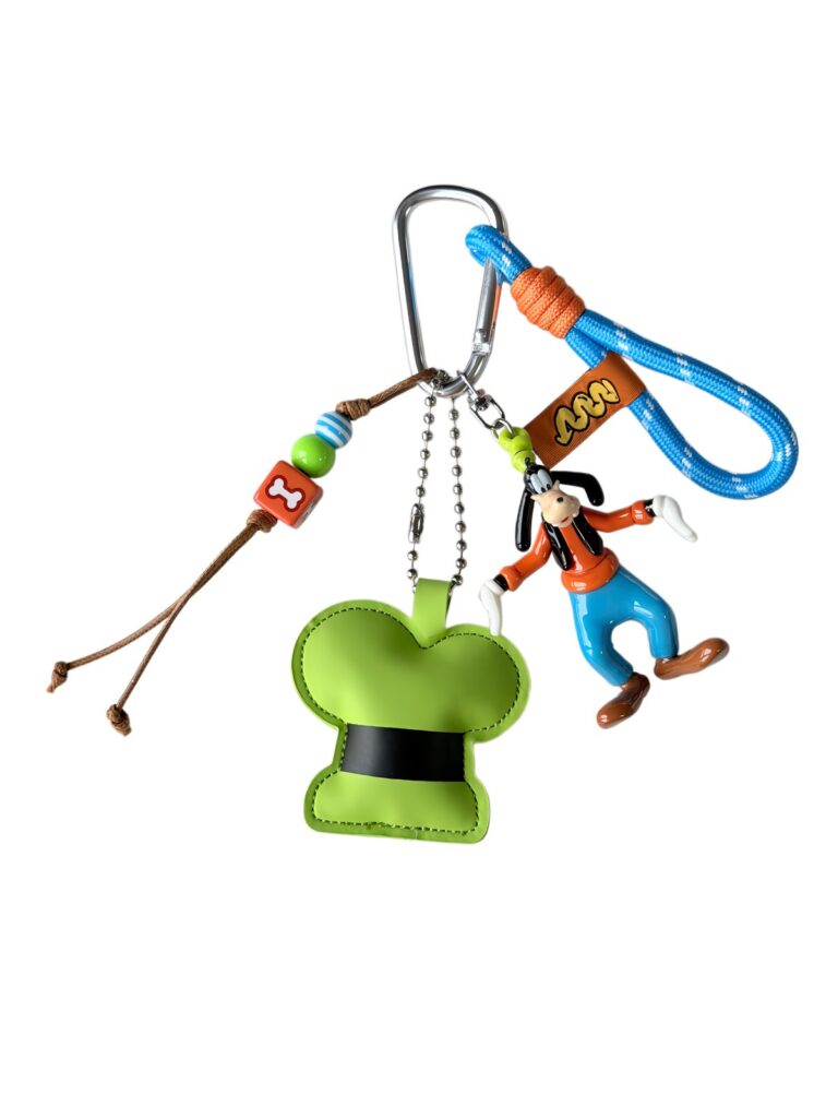 Bag charm set with a green glove-shaped charm, orange-and-blue figure and blue wrist loop