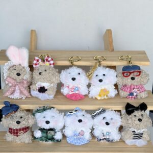 Ten dressed fuzzy animal charms on a wooden display