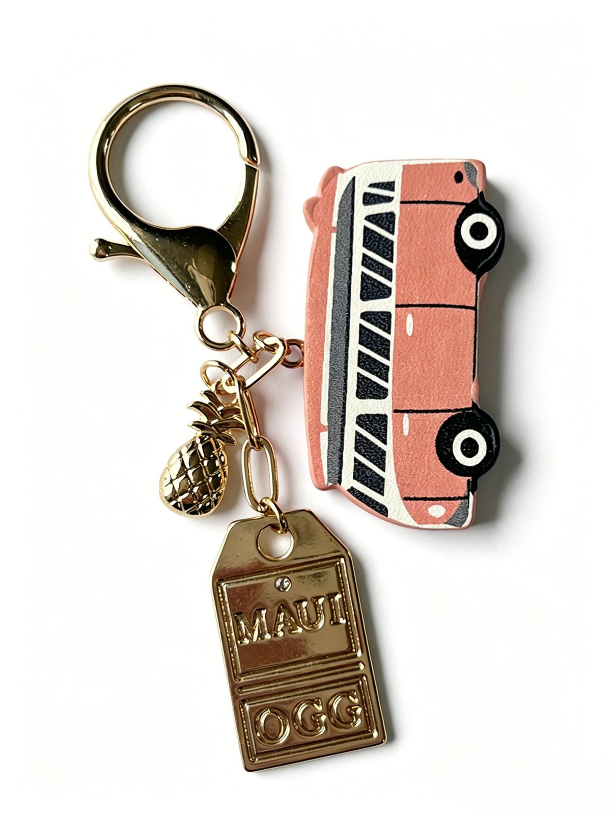 Pink bus-shaped keychain with a gold-tone clasp and small metal charms