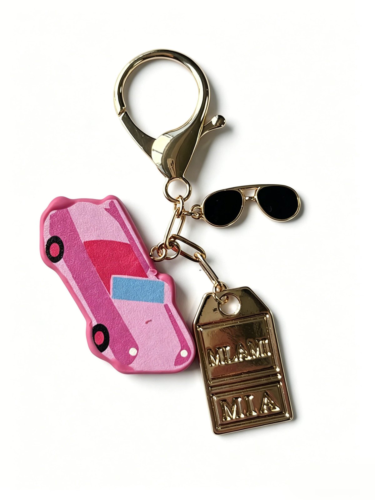 Pink car-shaped keychain with a small sunglasses charm and gold-tone clasp