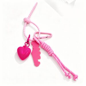 Heart and word charms with knotted cord tassels and clasp in pink, red, white, shown as a clip-on charm.