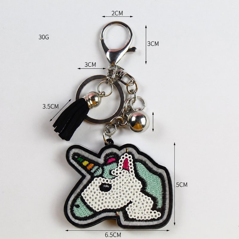 Sequin unicorn-head keychain with a black tassel, clasp and size measurements