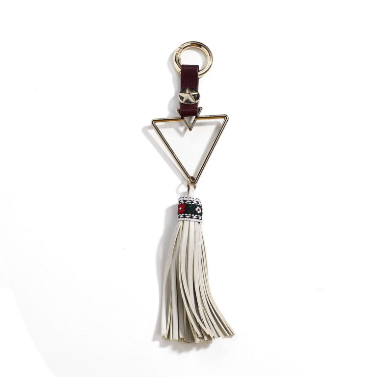 Triangular gold-tone charm with a cream tassel and burgundy hanging loop