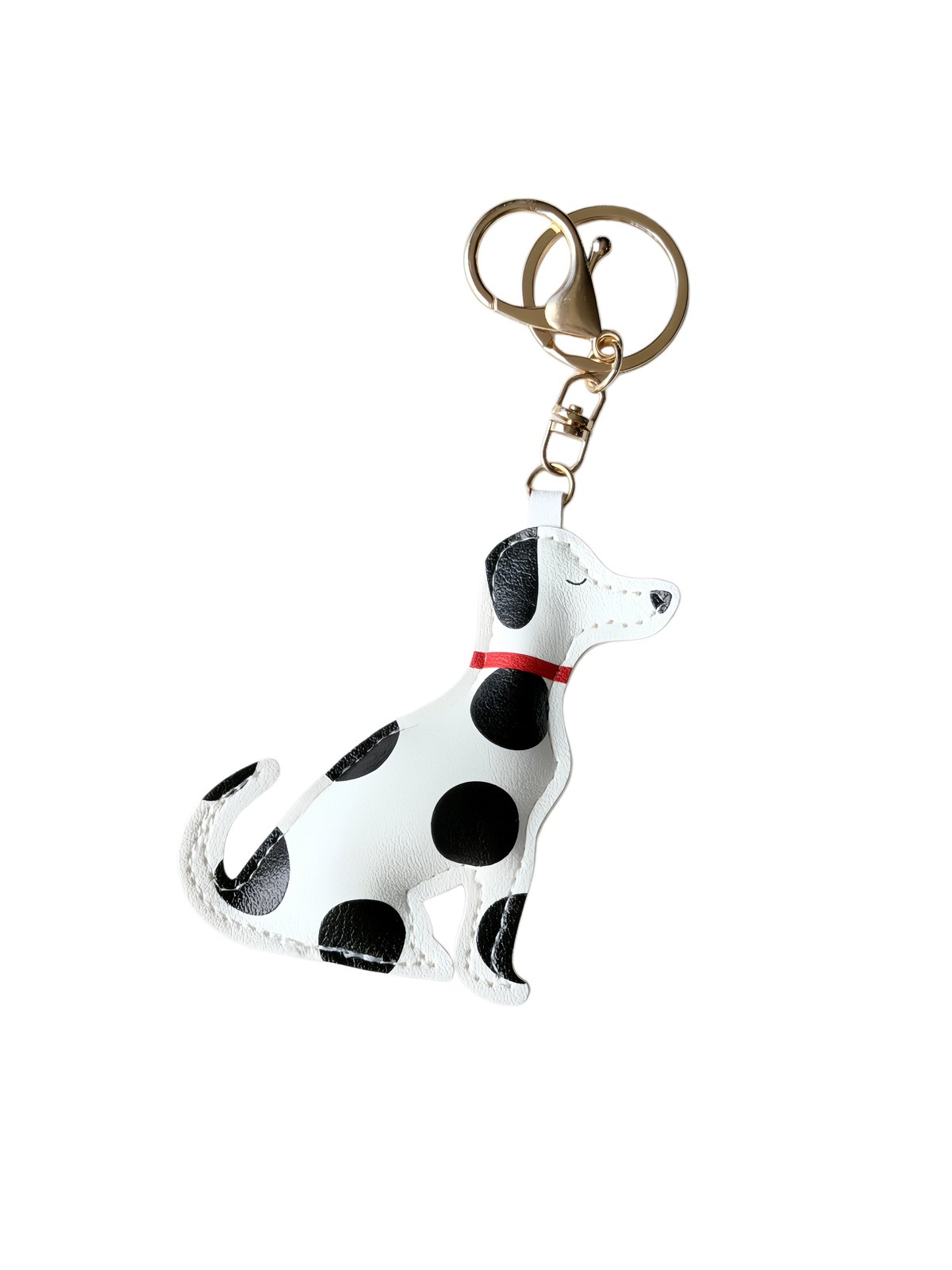 Spotted dog-shaped padded charm with ring and clasp in white, black, red, gold-tone, shown as a keychain.