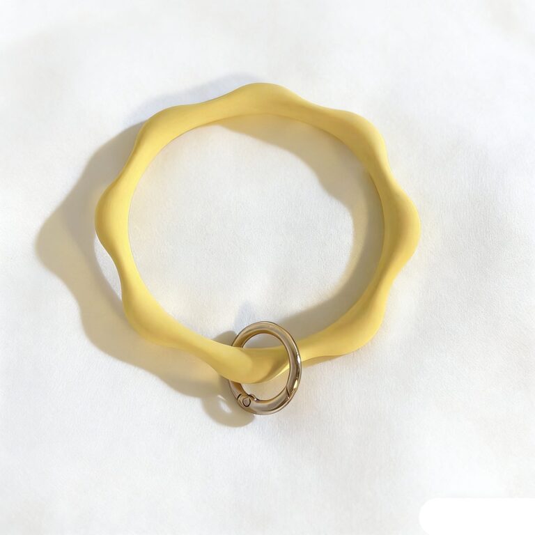 Pale-yellow wavy-edged phone bangle with a gold-tone attachment ring