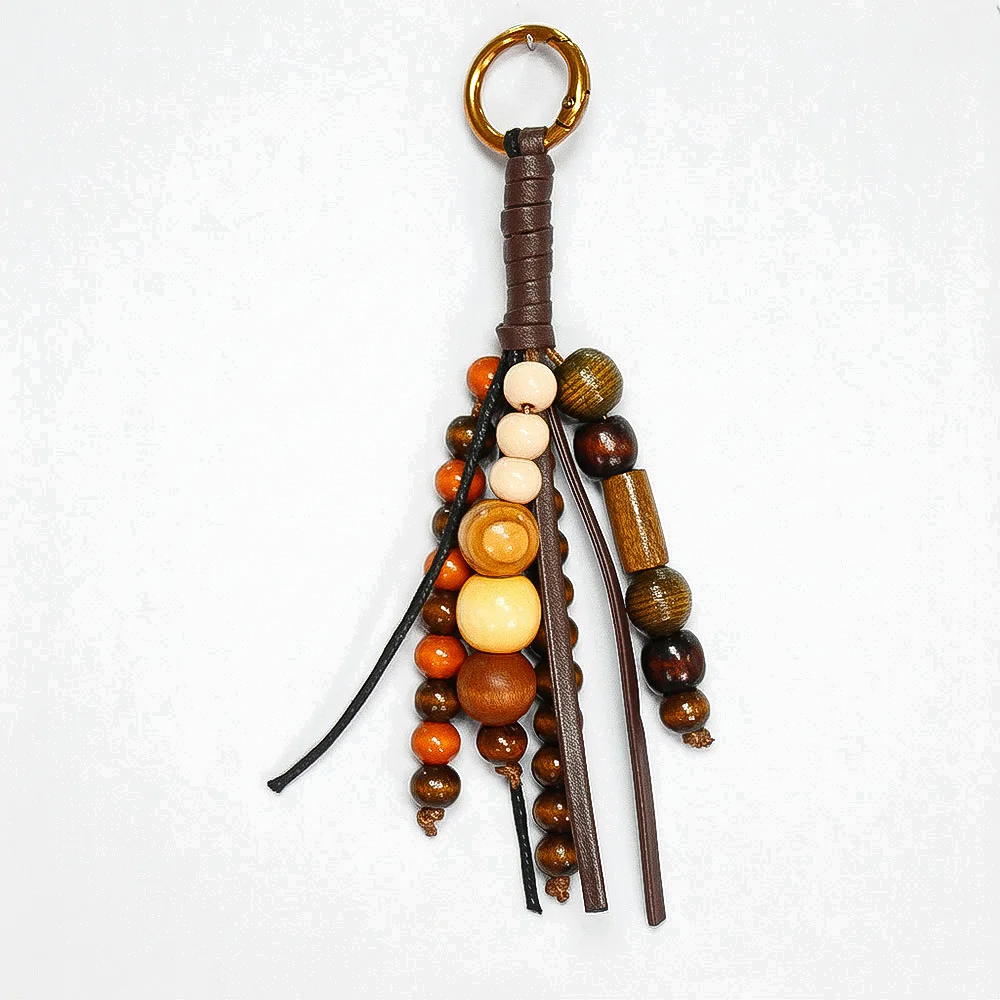Custom brown leather cord bag charm with beads and metal clasp for retail-ready collections.