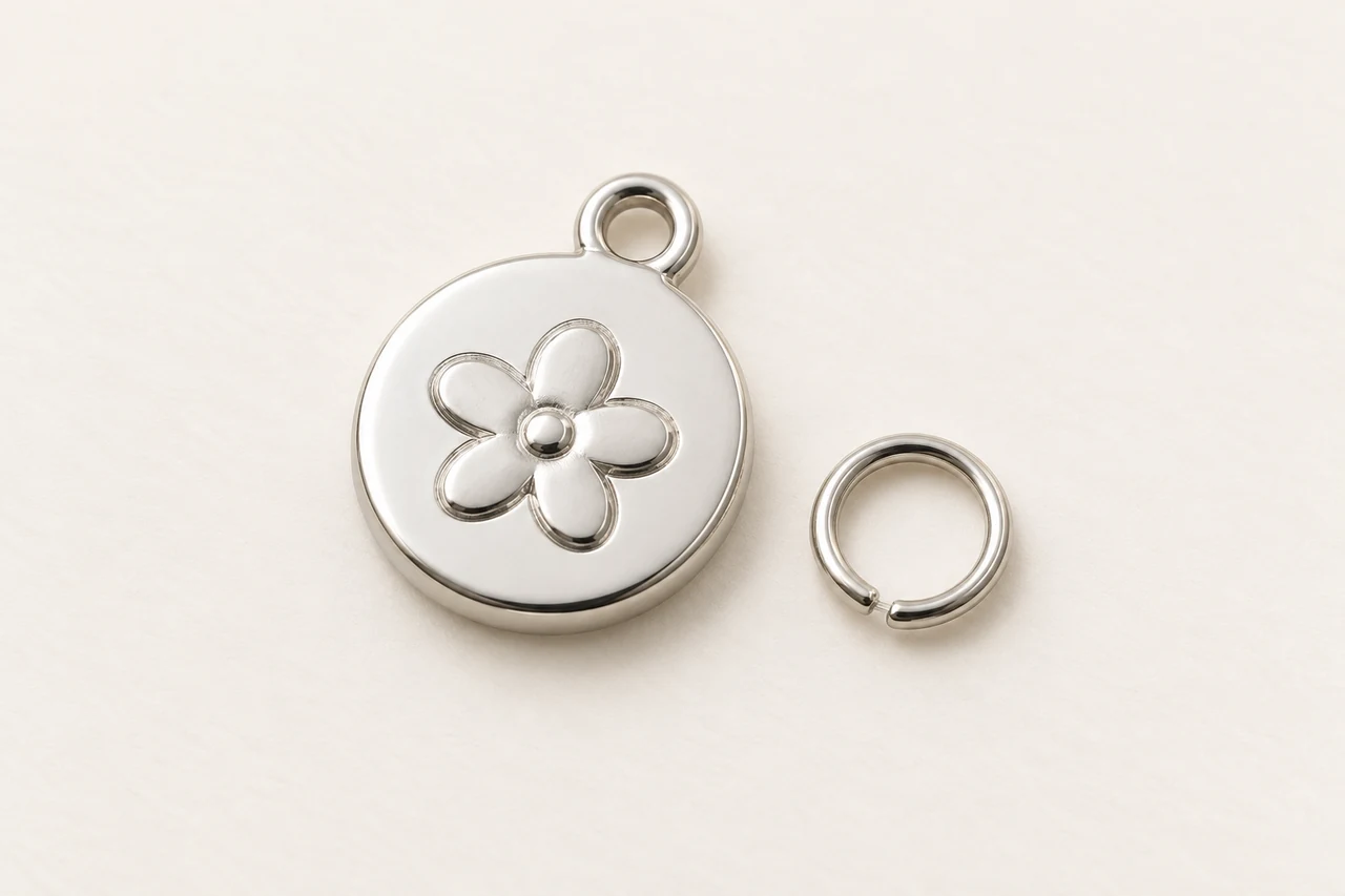 AI-generated concept: Round silver-tone decorative tag with a raised flower motif and a separate ring.