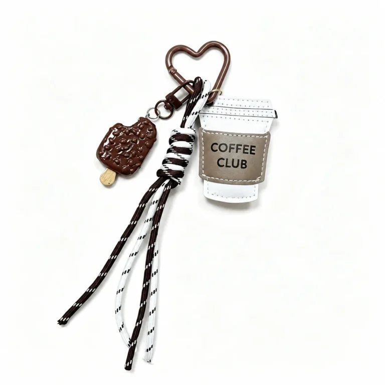 Takeaway cup charm with cookie and cord tassels and heart clasp in cream, brown, black, white, silver-tone, shown as a clip-on charm.