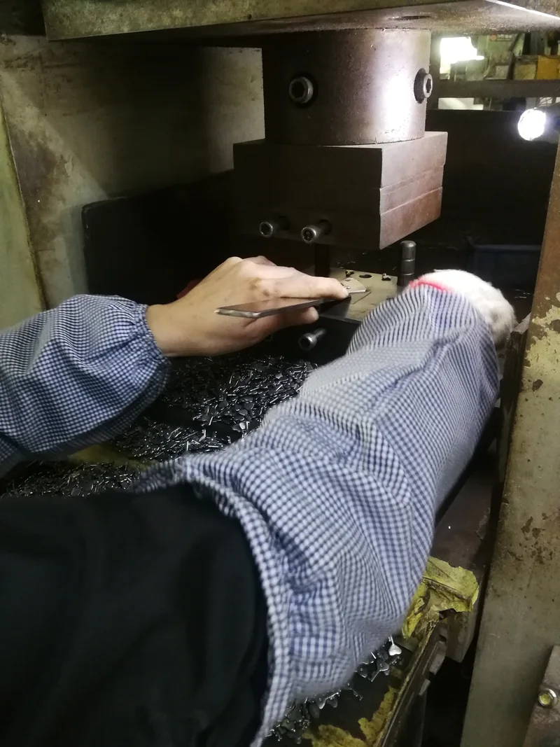 December 2019 metal factory archive: hands positioning a small component at a workshop tool