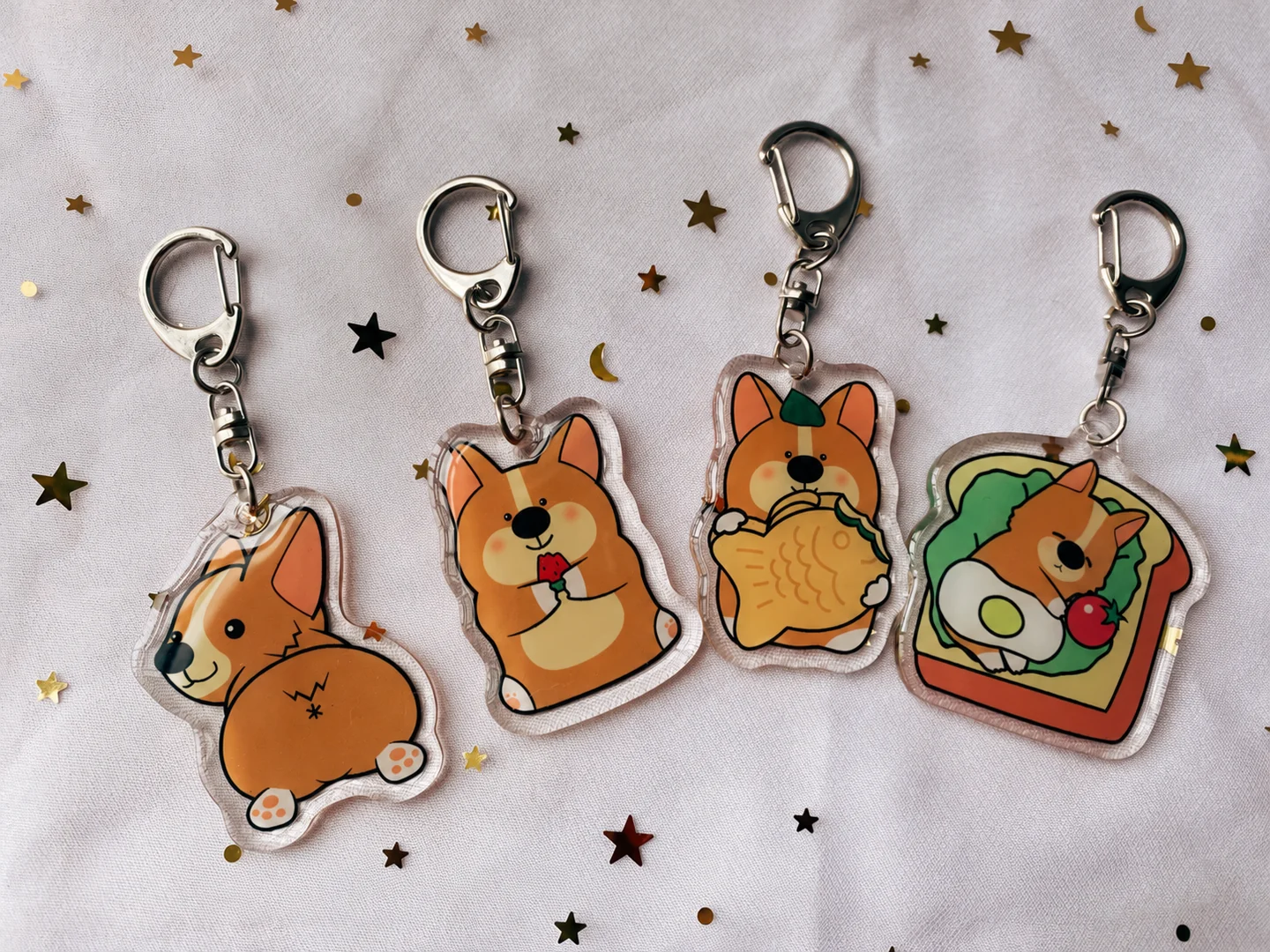 Four illustrated dog keychains with clear outer edges, individual connecting rings and metal-tone clips.