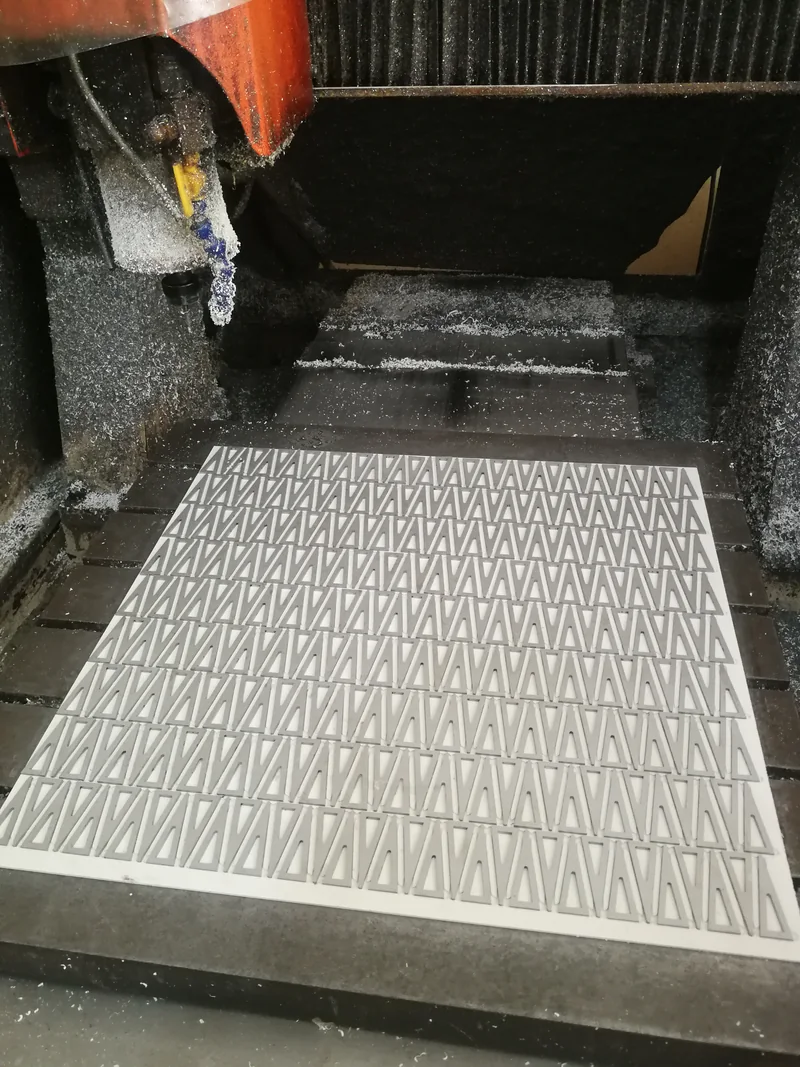 Machine head above a panel with repeated triangular patterns