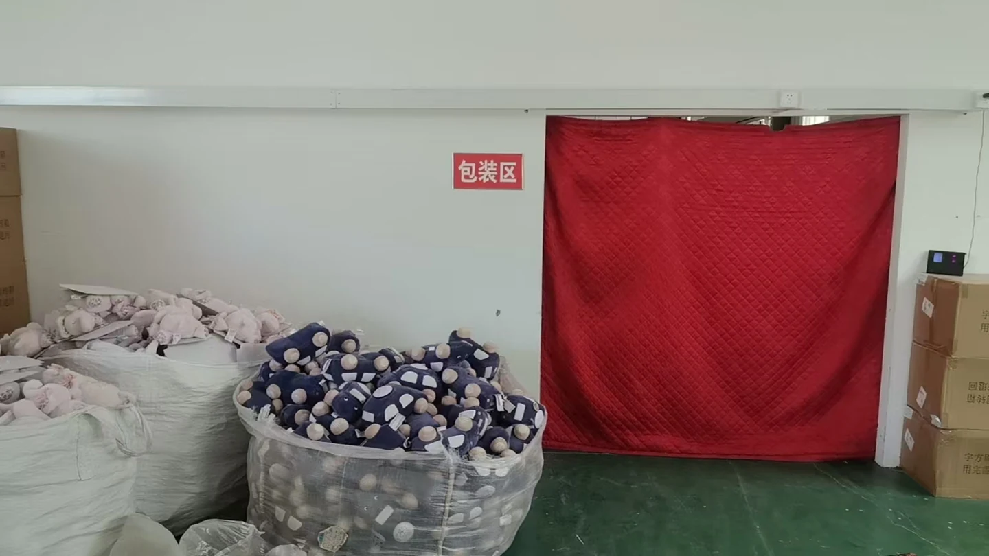 Marked factory packing area with bagged plush pieces and handling cartons