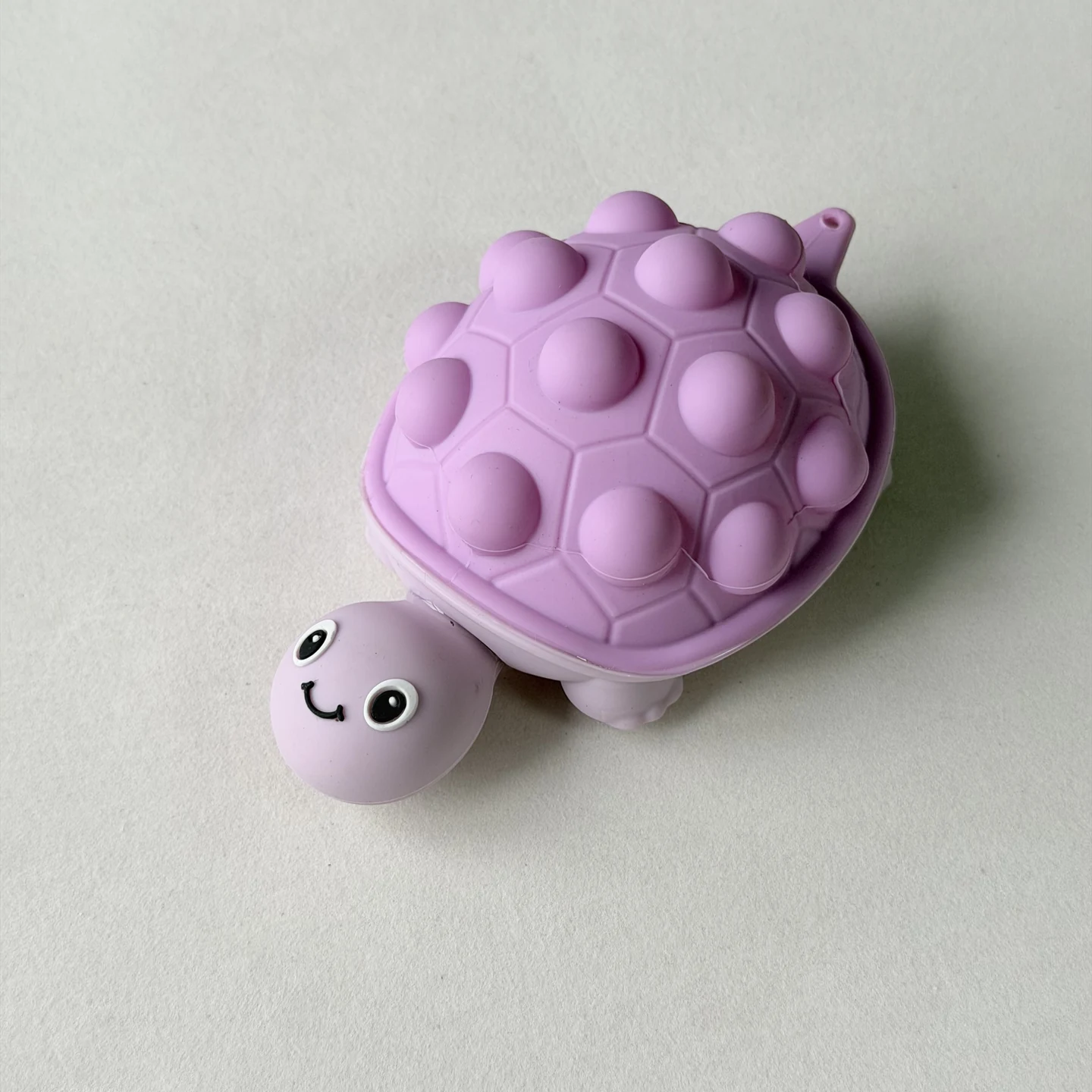 Purple turtle-shaped sample with raised shell details and a visible connection hole at the tail.
