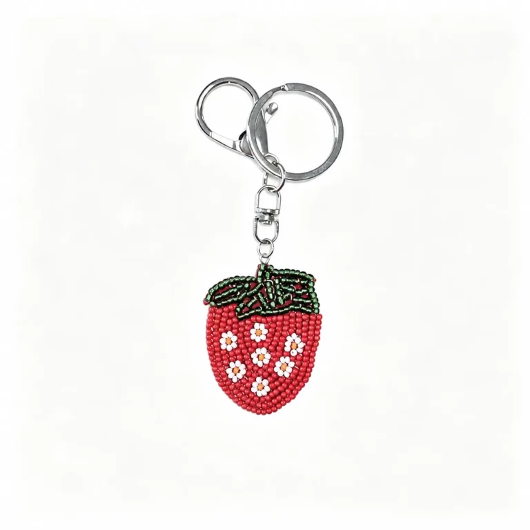 Beaded strawberry charm with clasp and round ring in red, green, white, silver-tone, shown as a keychain.