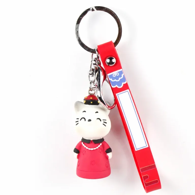 Cat figure wearing robe with printed loop strap and key ring in white, red, silver-tone, shown as a keychain.