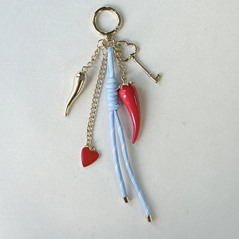 Red pointed charm, heart and key details with blue wrapped cord and gold-tone chains