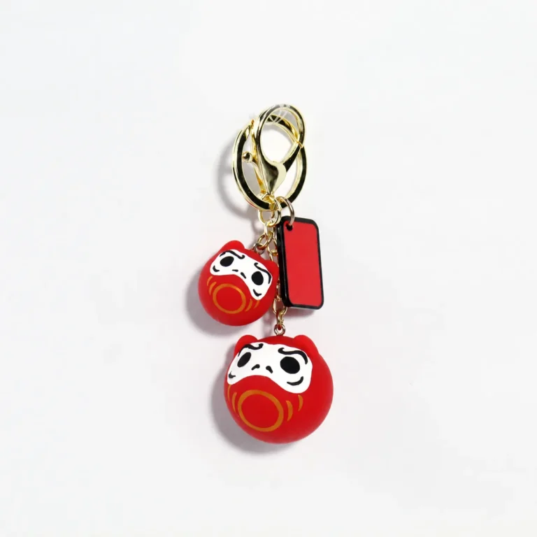 Red daruma figure keyring with matching round charm