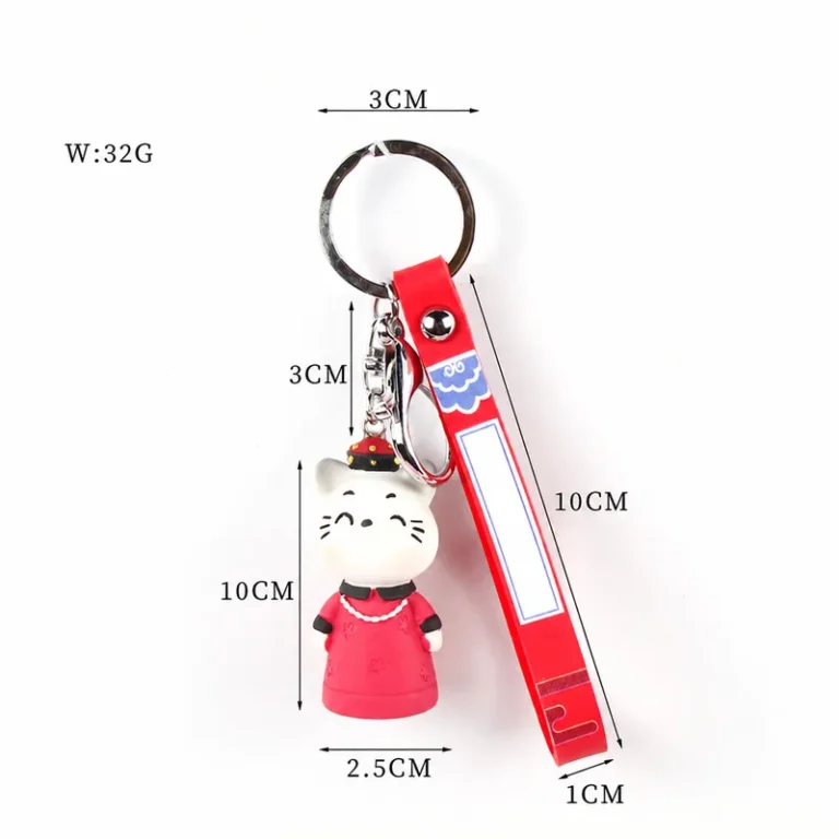 Cat figure wearing robe with printed loop strap and key ring in white, red, silver-tone, shown as a keychain.