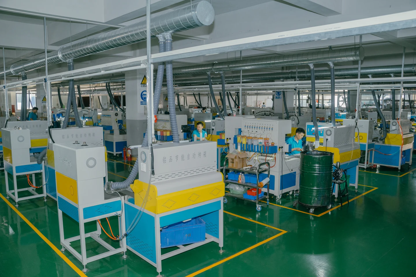 Multiple workshop workstations with feed cylinders, ventilation ducts and operators