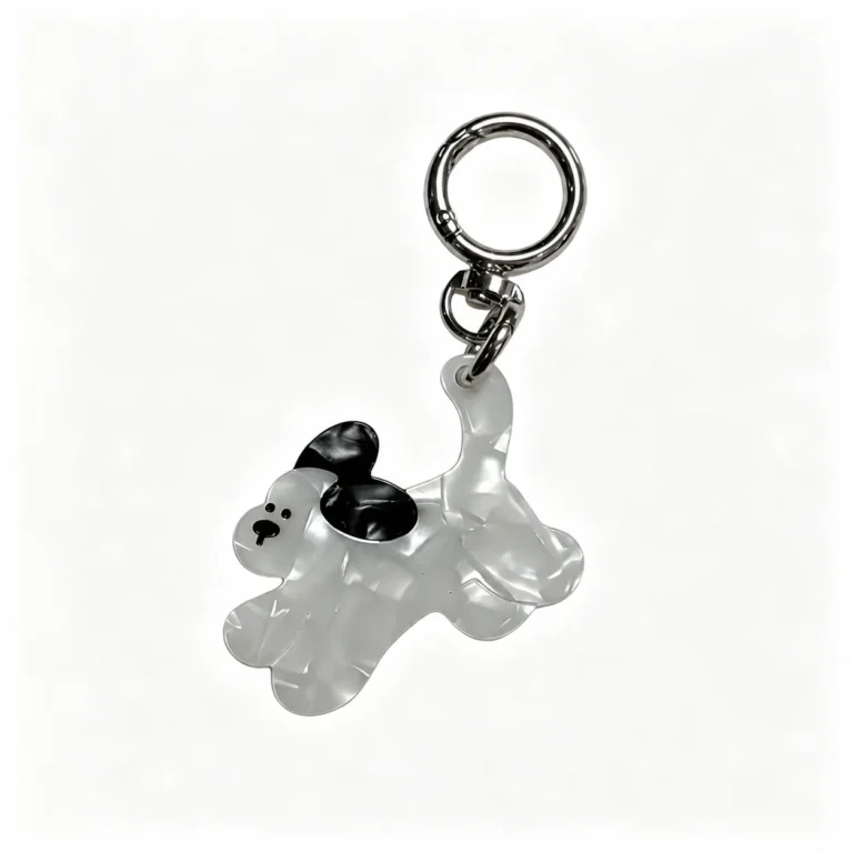 Curled-tail animal charm with round ring in white, black, silver-tone, shown as a keychain.
