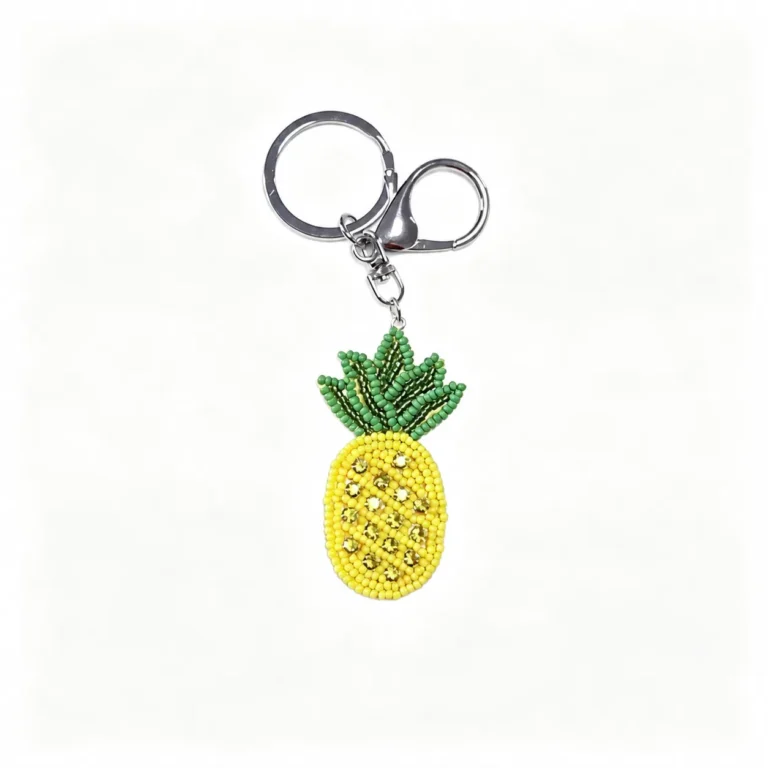 Beaded pineapple charm with clasp and round ring in yellow, green, silver-tone, shown as a keychain.